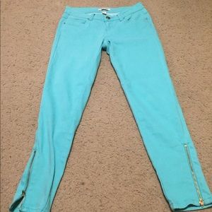 Turquoise pants with gold zippers on bottom